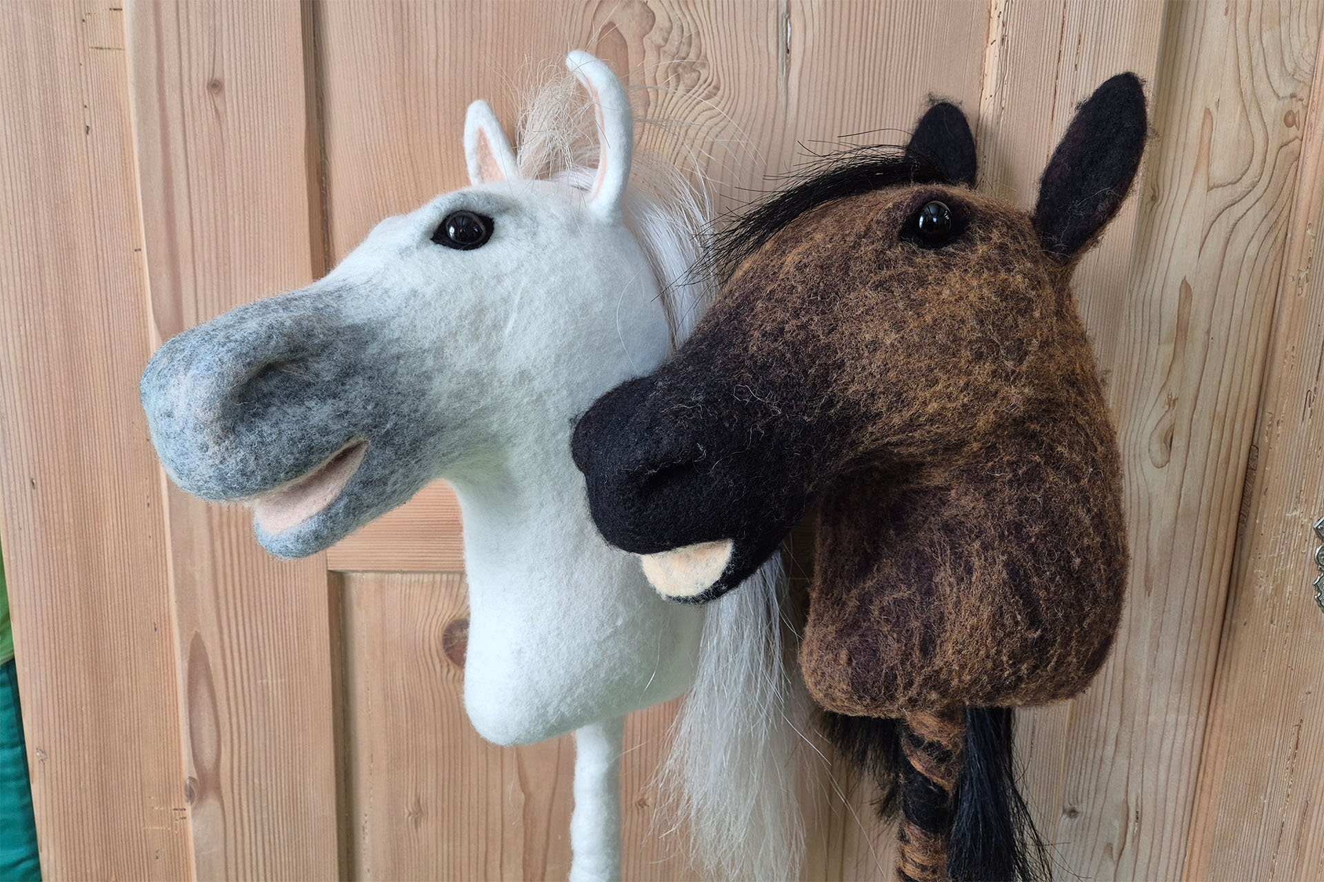 Weisse und braune Filz-Pferdeköpfe.