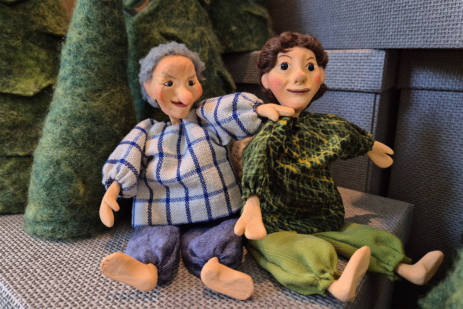 Zwei Figuren mit einmal blauer Kleidung und einmal grüner Kleidung.